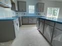 Spacious kitchen featuring gray cabinets, stone countertops, and stainless steel appliances at 173 Grove Township Way, Angier, NC 27501