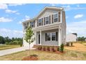 Charming two-story home with siding, a covered porch, and a young tree in the front yard at 178 Grove Township Way, Angier, NC 27501