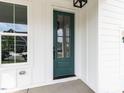 Close-up of a green front door with glass panels, set against a white-trimmed exterior at 1813 Bright Lantern Way, Wendell, NC 27591