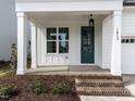 Inviting front porch with brick steps, classic columns, and a stylish green front door with sidelight at 1813 Bright Lantern Way, Wendell, NC 27591