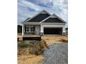 New construction featuring a two-car garage and covered front entry awaiting landscaping at 19 E American Marigold Dr # 34, Benson, NC 27504