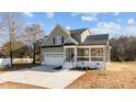 Two-story house with a stone and shingle exterior, front porch, and a two-car garage at 20 Wes Sandling Rd, Franklinton, NC 27525