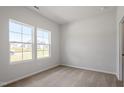 Bright bedroom with neutral carpet, two large windows, and white walls at 211 Grove Township Way, Angier, NC 27501