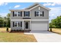 Two-story home featuring a front-facing, two car garage and gray siding at 211 Grove Township Way, Angier, NC 27501