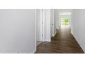 Bright hallway featuring wood-look floors and white doors at 211 Grove Township Way, Angier, NC 27501