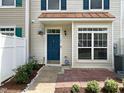 Front entry of a townhouse with a teal door and brick walkway at 2221 Valley Edge Dr # 105, Raleigh, NC 27614