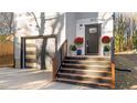 Modern home entrance with dark door, wooden stairs, and landscaping at 2513 Rochelle St, Durham, NC 27703