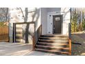 Modern home entrance with dark door, wooden stairs, and landscaping at 2513 Rochelle St, Durham, NC 27703
