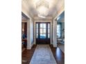 Grand foyer featuring a beautiful chandelier, hardwood floors, and a decorative rug at 2900 Glenanneve Pl, Raleigh, NC 27608