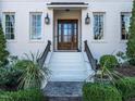 Close up of the front entrance showing a beautiful wood door, white stairs, and manicured landscaping at 2900 Glenanneve Pl, Raleigh, NC 27608