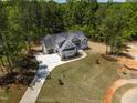 An aerial perspective showcases a home with pristine landscaping, a winding driveway, and lush tree coverage at 3925 Cedar Knolls Dr, Youngsville, NC 27596