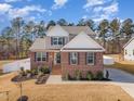 Attractive two-story home featuring brick accents, a landscaped yard, a paved walkway, and a well-kept lawn at 40 Ironwood Blvd, Youngsville, NC 27596