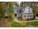Inviting gray home with lush landscaping, mature trees, and a circular driveway, offering classic charm and curb appeal at 4201 Henderson Pl, Pittsboro, NC 27312