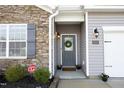 Inviting front entrance with gray door and stonework at 6109 Watsonia Dr, Zebulon, NC 27597