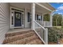 Brick steps leading up to a charming front porch with white railings at 63 Eastland Ct, Smithfield, NC 27577