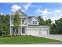 Beautiful two-story house boasting a double-decker porch, a lush lawn, and a large three-car garage at 125 Charlotte Knoll St # 15, Zebulon, NC 27597