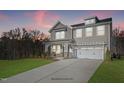 Two-story home with gray siding, white trim, and a two-car garage at dusk at 178 Charlotte Knoll St # 9, Zebulon, NC 27597
