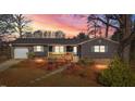 Charming single-story home with a well-maintained front yard and inviting covered porch at sunset at 1219 Carlton Ave, Burlington, NC 27217
