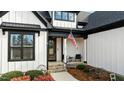 Inviting front porch with American flag and brick steps at 15 Willow Bend Dr, Youngsville, NC 27596