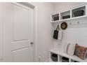 White mudroom with bench seating, cubbies, and hooks for bags at 2326 Sugar Cone Way, Fuquay Varina, NC 27526