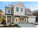 Two-story townhome with gray and beige siding, stone accents, and a covered entryway at 2330 Sugar Cone Way, Fuquay Varina, NC 27526
