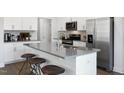 Modern kitchen with white cabinets, gray countertops, stainless steel appliances, and an island at 2336 Sugar Cone Way, Fuquay Varina, NC 27526