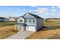 Two-story home with blue siding, a two-car garage, and concrete driveway at 2995 Faucette Ln, Burlington, NC 27217