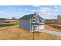 Side view of a two-story home with blue siding, white trim and an orange front door at 2995 Faucette Ln, Burlington, NC 27217