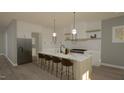 Well-lit kitchen boasts stainless steel appliances, a spacious island with bar seating, and stylish pendant lights at 3813 Peaceful Creek Trl, Zebulon, NC 27597