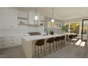 Open concept kitchen features a large island, modern lighting, and seamless connection to the dining area at 3813 Peaceful Creek Trl, Zebulon, NC 27597