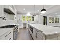 Modern kitchen with white cabinets, large island, and stainless steel appliances at 3813 Peaceful Creek Trl, Zebulon, NC 27597