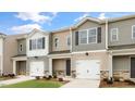 Three-unit townhome building with gray and beige siding, two-car garages, and landscaping at 422 Honeycutt Oaks Dr, Angier, NC 27501