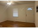 Bright living room featuring hardwood floors, a ceiling fan, and a front door with decorative window at 494 S Mason St, Coats, NC 27521