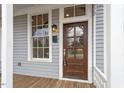 Close-up of the front door with a sidelight, lantern, and porch with wood floors and a white column at 520 S Bloodworth St, Raleigh, NC 27601