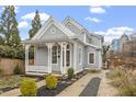 Charming two-story home with a decorative porch, manicured landscaping, and a view of the city skyline in the background at 520 S Bloodworth St, Raleigh, NC 27601