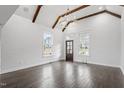 Bright living room with vaulted ceiling, exposed wood beams, chandelier, large windows, and hardwood floors at 520 S Bloodworth St, Raleigh, NC 27601