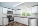 Renovated kitchen with white cabinets, stainless steel appliances, and dark countertops at 621 Shepard School Rd, Zebulon, NC 27597