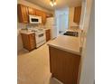 Galley kitchen with light wood cabinets and white appliances at 7309 Brighton Hill Ln, Raleigh, NC 27616