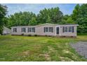 Tan mobile home exterior on a grassy lot at 95 Old Barn Ct, Rocky Mount, NC 27801