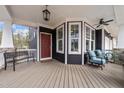 Inviting front porch with seating, an overhead fan, and elegant bay windows at 101 Pointe Park Cir, Holly Springs, NC 27540