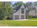 Side angle showcasing attached two-car garage and the beautifully maintained landscaping of this home at 1304 Ivy Ln, Raleigh, NC 27609