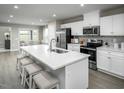 Modern kitchen with white cabinets, island, and stainless steel appliances at 1425 Rollman Farm Rd, Raleigh, NC 27603