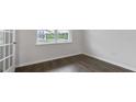 A serene, empty room featuring hardwood floors, base trim and a window with beautiful natural light at 145 Scenic Rock Dr, Youngsville, NC 27596