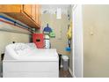 Functional laundry area with a washing machine and upper and lower storage cabinets for supplies at 1587 Crockers Nub Rd, Middlesex, NC 27557