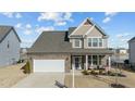 Two-story house with a stone facade, two-car garage, and landscaped yard at 2120 Blue Iris Way, Zebulon, NC 27597