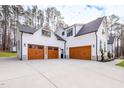 Three-car garage with brown doors and white siding, attached to a farmhouse at 257 Rawhide Dr, Louisburg, NC 27549