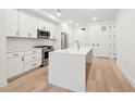 Open concept kitchen with white cabinetry, stainless steel appliances, and a center island at 29 Enterprise St # 107, Raleigh, NC 27607