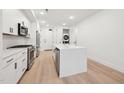 Modern kitchen with stainless steel appliances, white cabinets, and a center island at 29 Enterprise St # 107, Raleigh, NC 27607