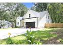 White farmhouse exterior with black accents, two-car garage, and manicured lawn at 30 Cicada Dr, Franklinton, NC 27525