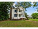 Two-story white house with blue shutters, wraparound porch, and landscaped lawn at 309 Hawkins Ave, Sanford, NC 27330
